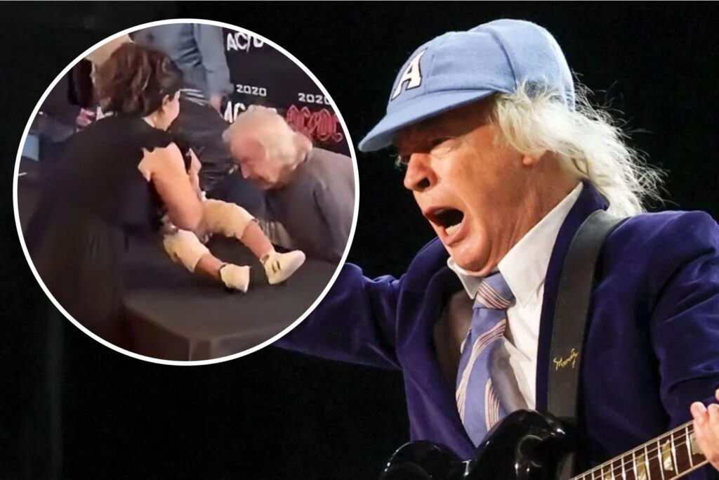 Angus Young firma un bebe de un fan en Toronto durante un evento sorpresa