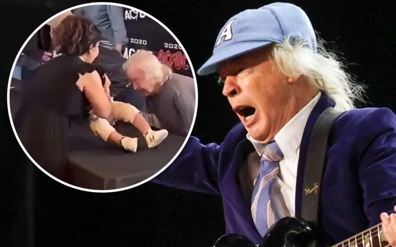 Angus Young firma un bebe de un fan en Toronto durante un evento sorpresa