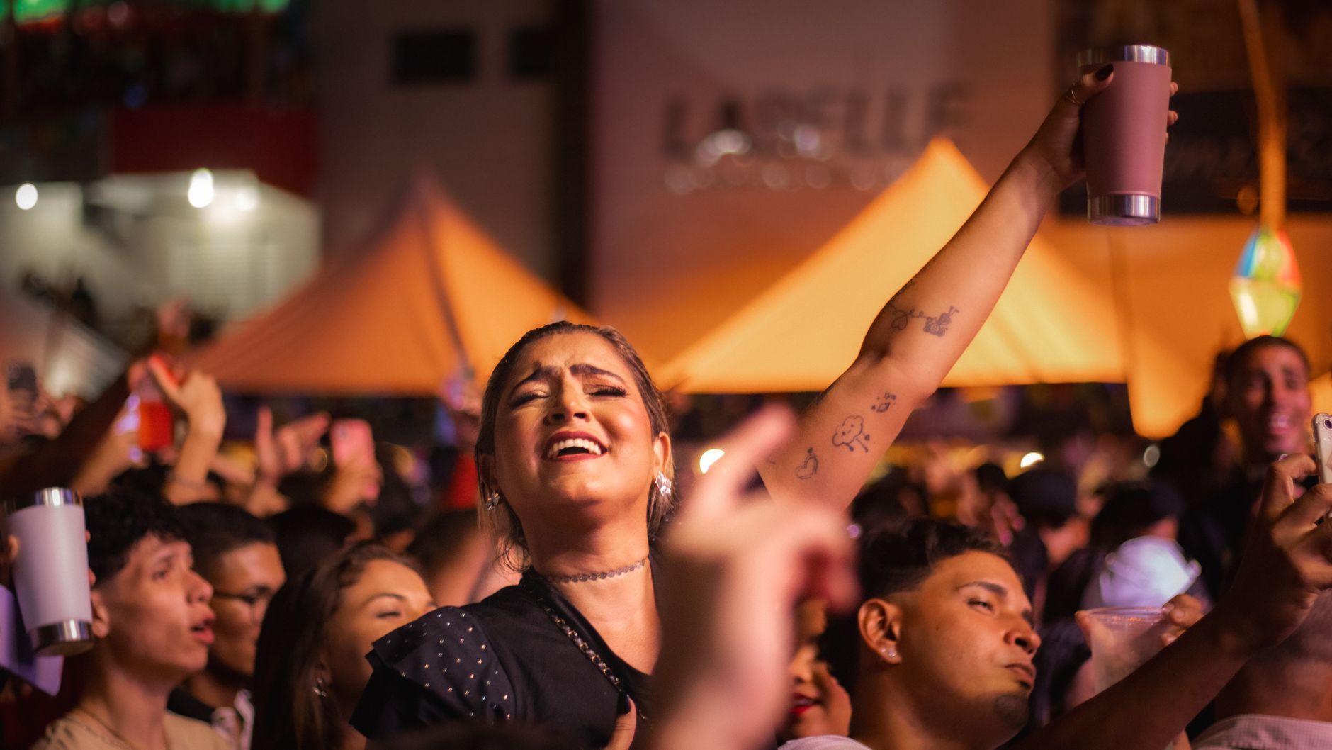 Multitud disfrutando de una fiesta nocturna, imagen ilustrativa del público del reguetón