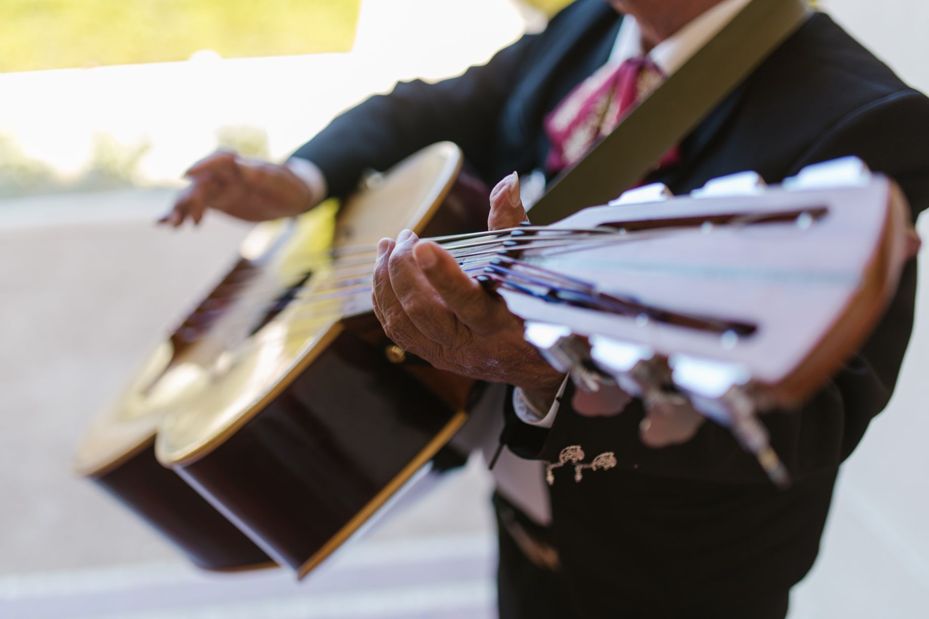 Músico tocando una guitarra acústica durante una presentación, imagen ilustrativa de la música regional mexicana de Fuerza Regida