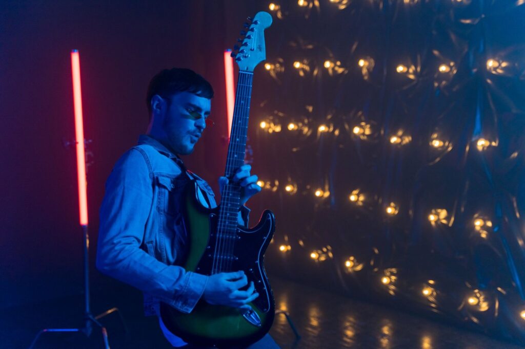 Guitarrista tocando una guitarra eléctrica bajo luces de escenario, imagen ilustrativa de My Chemical Romance The Black Parade
