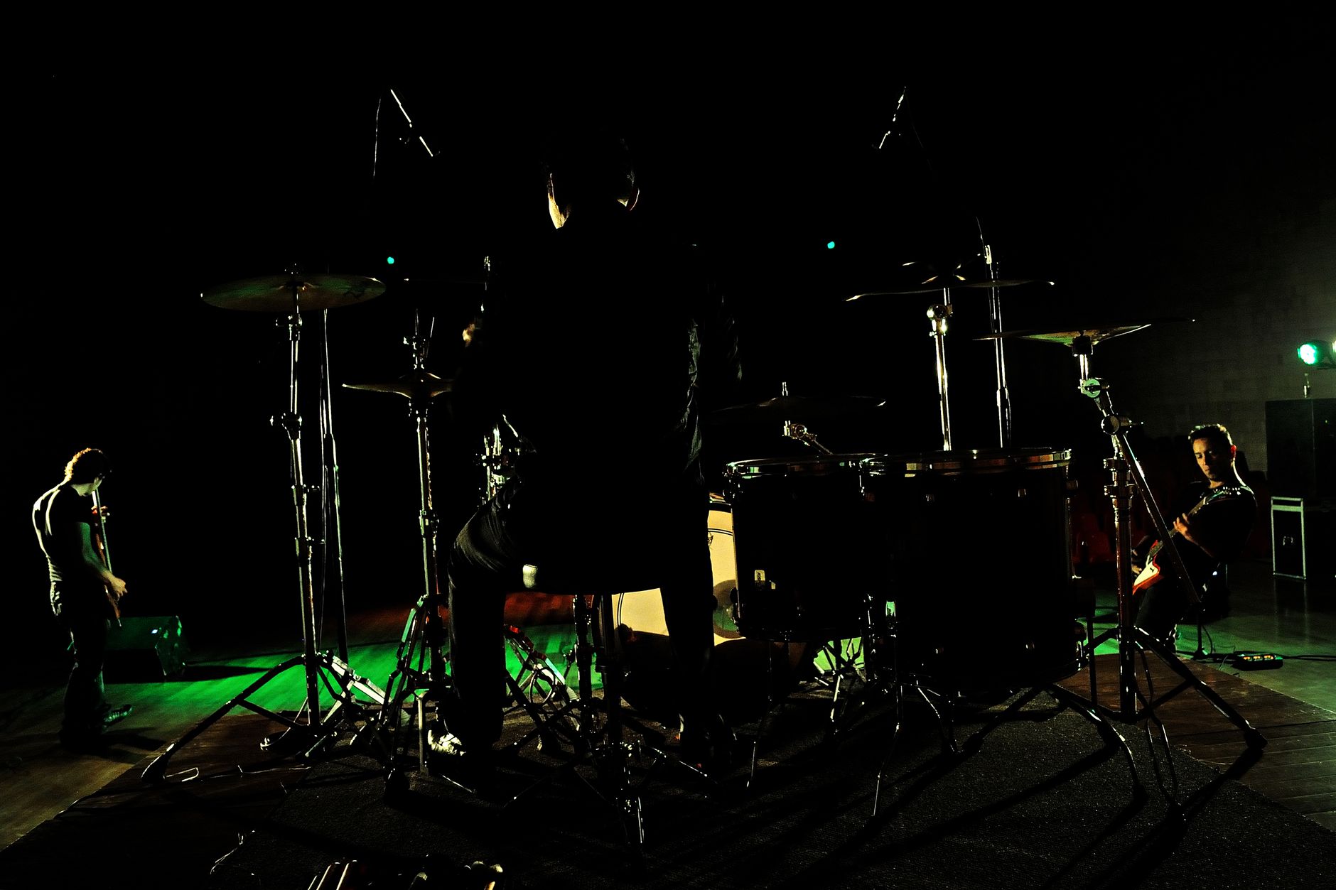 Banda de rock con siluetas bajo las luces del escenario, imagen de referencia del festival Power to the People