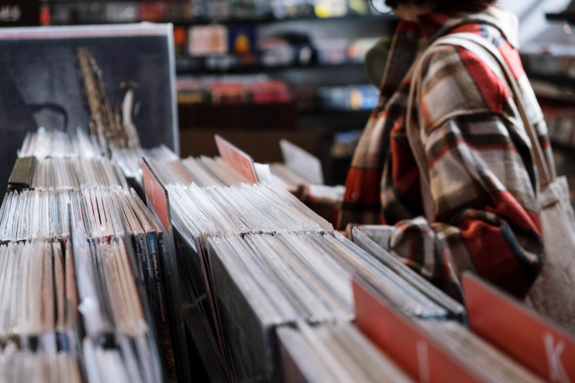 Persona explora vinilos clásicos en una tienda, como en el Black Friday de Record Store Day