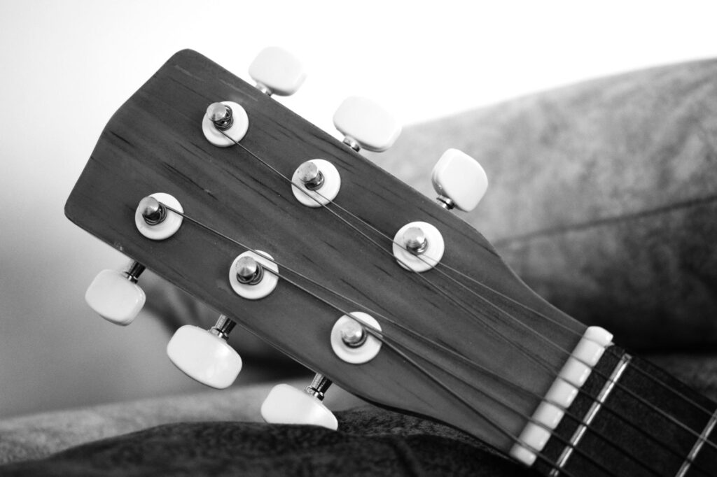 Primer plano en blanco y negro del clavijero de una guitarra acústica, imagen ilustrativa de la canción High And Dry de Radiohead